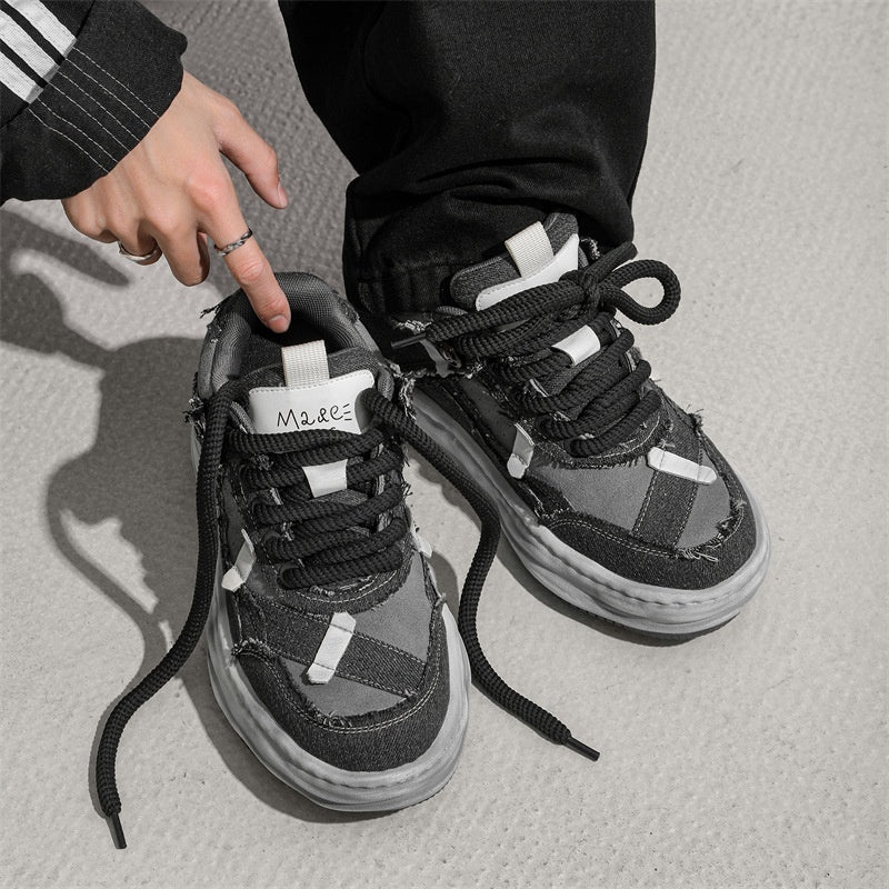 Black and gray sneakers with white accents on a light gray background