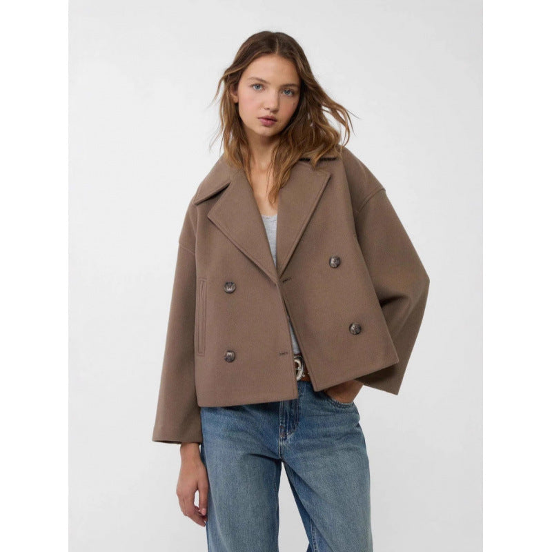 Woman wearing a brown coat and blue jeans on a white background