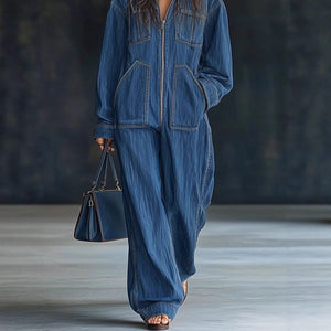 Person wearing a blue denim outfit holding a matching handbag on a neutral background